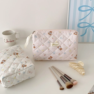 Detailed view of quilted makeup bags with cute bear embroidery and white ribbon zipper