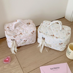 Dettaglio della borsa da toilette trapuntata con graziosi motivi floreali e conigli