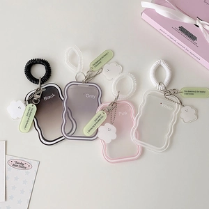 Close-up of wavy edge card holders in four colors with spiral wristbands and cloud charms