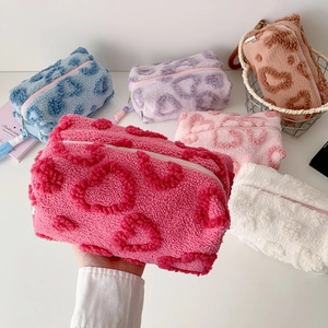 Plush heart-patterned cosmetic bags in various colors with soft teddy fleece texture