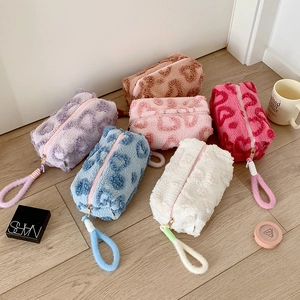 Detail of plush heart-embossed storage bags in various colors with soft teddy fleece texture