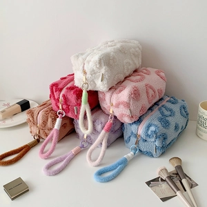 Detail of plush cosmetic bags with embossed heart patterns and gold metal zippers