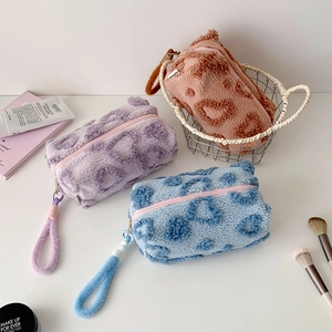 Detail of plush lamb wool pouches with heart patterns in purple blue and brown