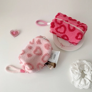 Detail of plush heart-patterned stationery bags in rose and light pink colors