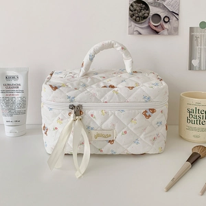 Dettaglio della borsa da toilette trapuntata bianca con orsetti e tiranti in nastro