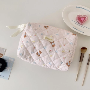 Dettaglio della trousse rosa trapuntata con orsetti e fiocco sulla cerniera lampo
