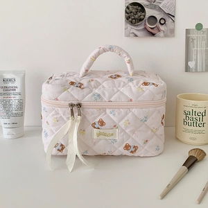 Dettaglio della borsa da toilette rosa trapuntata con orsetti e cerniera a nastro