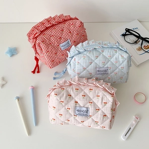 Three quilted cherry pattern pencil cases with ruffled edges and zipper on white background