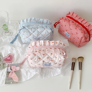 Quilted cherry plaid storage bags in light blue, pink and red with ruffled zipper detail