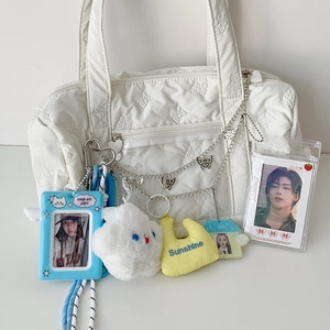 Detail of white quilted bag with butterfly texture and colorful DIY charms