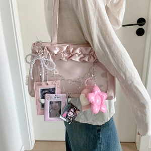 Pink satin pleated bag with DIY star chains, pearls and photo holders worn by a model