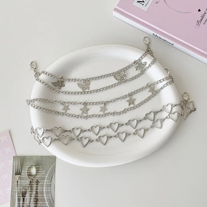 Silver star and butterfly metal charm chains for DIY bag accessories on a white plate