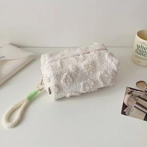 Dettaglio dell'astuccio bianco in pile testurizzato con cerniera rosa e maniglia