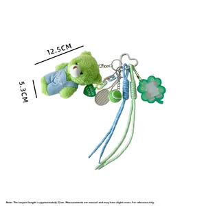 Dettaglio portachiavi orso di peluche verde con racchetta da tennis e ciondolo quadrifoglio
