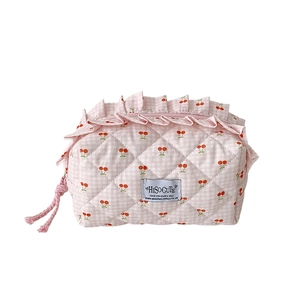 Pink checkered makeup bag with quilted cherry patterns and elegant ruffled edges