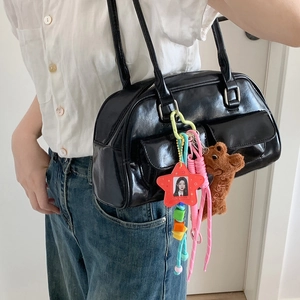 Portachiavi orsetto di peluche con cornice a stella su borsa in pelle nera lucida