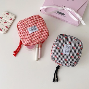 Dettaglio di trousse per il trucco a scacchi con ciliegie e logo HIsocute