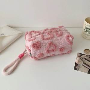 Dettaglio dell'astuccio in peluche rosa con consistenza morbida e robusto manico manuale