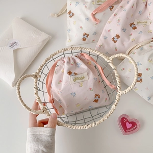 Detail of cute bear drawstring pouch set in woven basket for travel organization