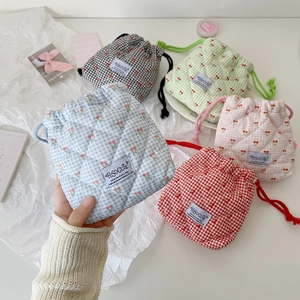 Quilted cherry drawstring cosmetic bags in five colors with grid patterns and tags