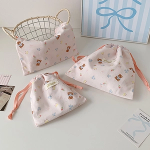Detailed macro view of three cute pink cotton drawstring bags with bear and rabbit prints