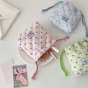 Quilted cherry drawstring cosmetic bags in pink, blue, and green plaid patterns
