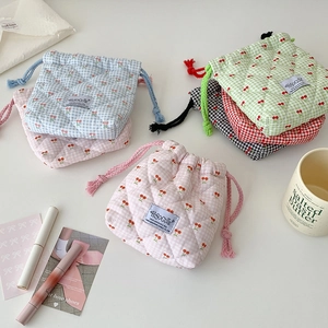 Close-up of quilted cherry pattern drawstring cosmetic bags with HISOGUTE label and cotton texture