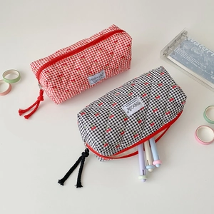 Detailed view of quilted cotton cherry pencil cases with red and black lattice texture