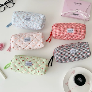 Quilted cherry print stationery bags in various colors on a clean white desk