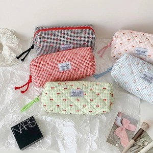 Detailed view of quilted cotton cherry pencil cases in five pastel colors on lace fabric