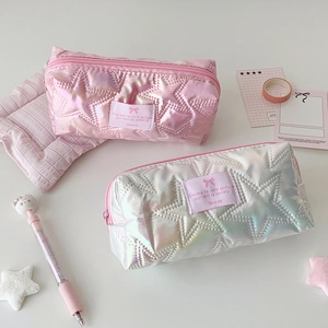 Detail of star-quilted metallic pencil cases in soft pink and silver with bow tag