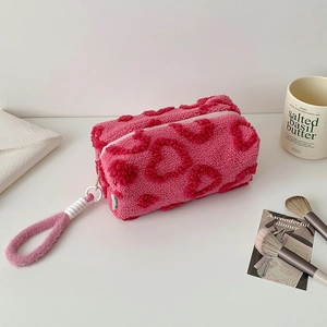 Dettaglio di astuccio in peluche rosa con cuori 3D e morbida consistenza in lana d'agnello