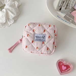 Detailed macro of pink quilted cherry storage pouch with zipper and fabric label