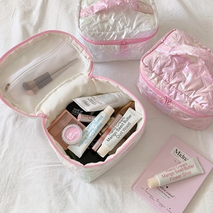 Star-quilted makeup bags in iridescent white and pink with top handles and inner mesh