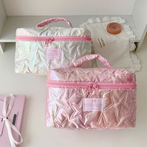 Detail of pink and white vanity bags with quilted star patterns and cute bow patches