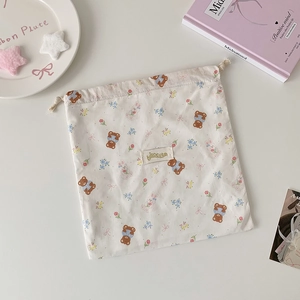 Detail of drawstring bag showing cute bear and bunny patterns with woven logo label