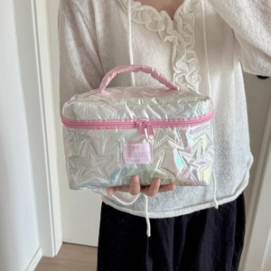Macro detail of star-quilted pearlescent makeup bag with pink zipper and handle