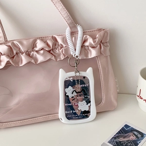 Cute white cat-ear photo card holder with elastic lanyard on a pink luxury bag
