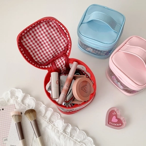 Three-piece set of portable cartoon cosmetic bags in red, pink, and blue with handles