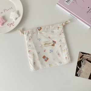 Detail of cute bear printed drawstring storage bag made of beige cotton linen fabric