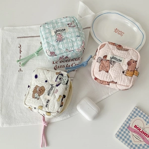 Detailed view of mini quilted cotton sanitary storage pouches with cute cartoon designs