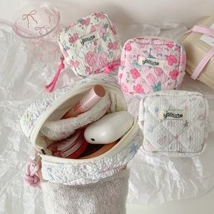 Quilted fabric cosmetic pouch with cartoon floral patterns and zip closure for storage