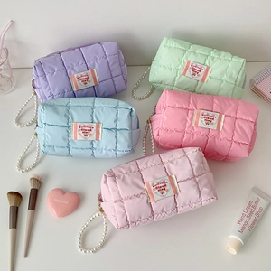 Quilted pastel makeup bags in macaron colors with pearl handles and soft textures