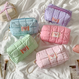 Quilted macaron color makeup bags with pearl straps and square stitching patterns