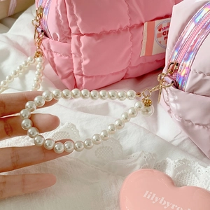 Close-up of pearl bead handle and golden lobster clasp on pink quilted storage bag