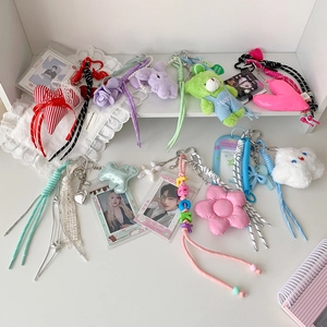 Close-up of cute plush bear and star pendants with colorful beads and photocard holders