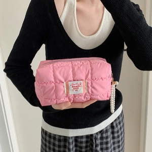 Pink quilted makeup bag with puff fabric, heart label and long pearl zipper pull detail