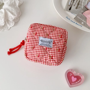 Detail of red cherry printed quilted cotton pouch with zipper for lipstick and keys