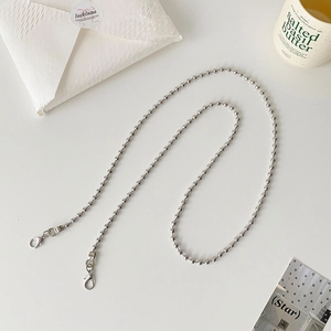 Dettaglio della catena a sfere in metallo argento con moschettoni per mini borse e cuffie