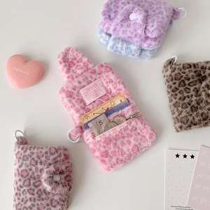 Detail of plush leopard print wallets featuring multiple card slots and secure snap closure